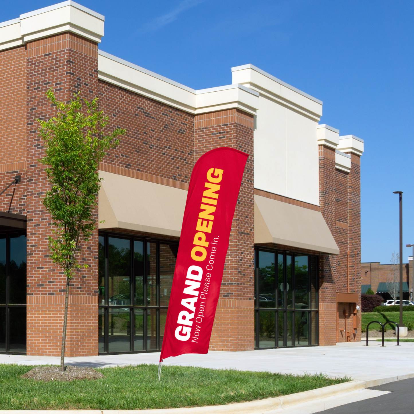 red, yellow, and white grand opening blade flag in front of building
