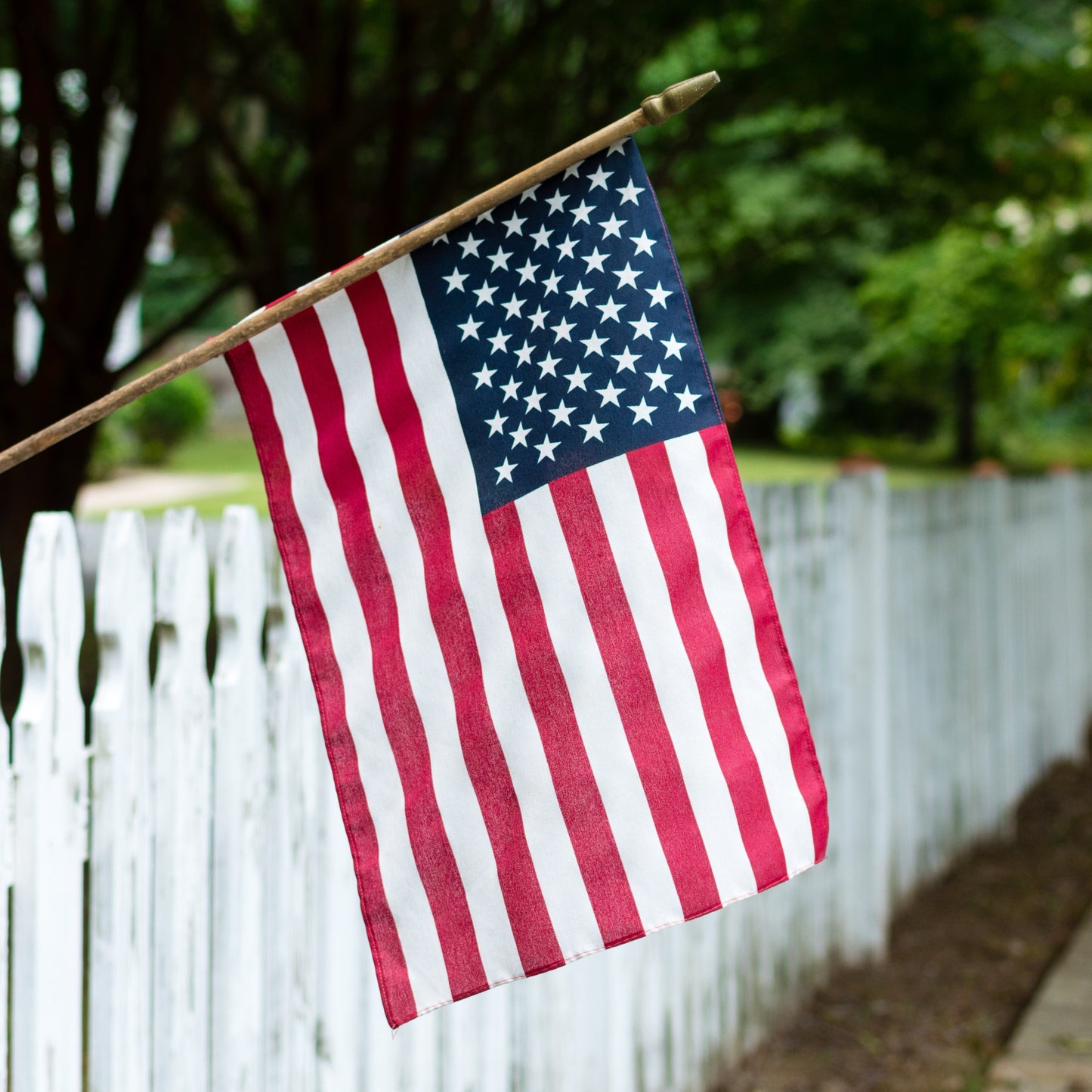 us flag sidewalk background with white fence