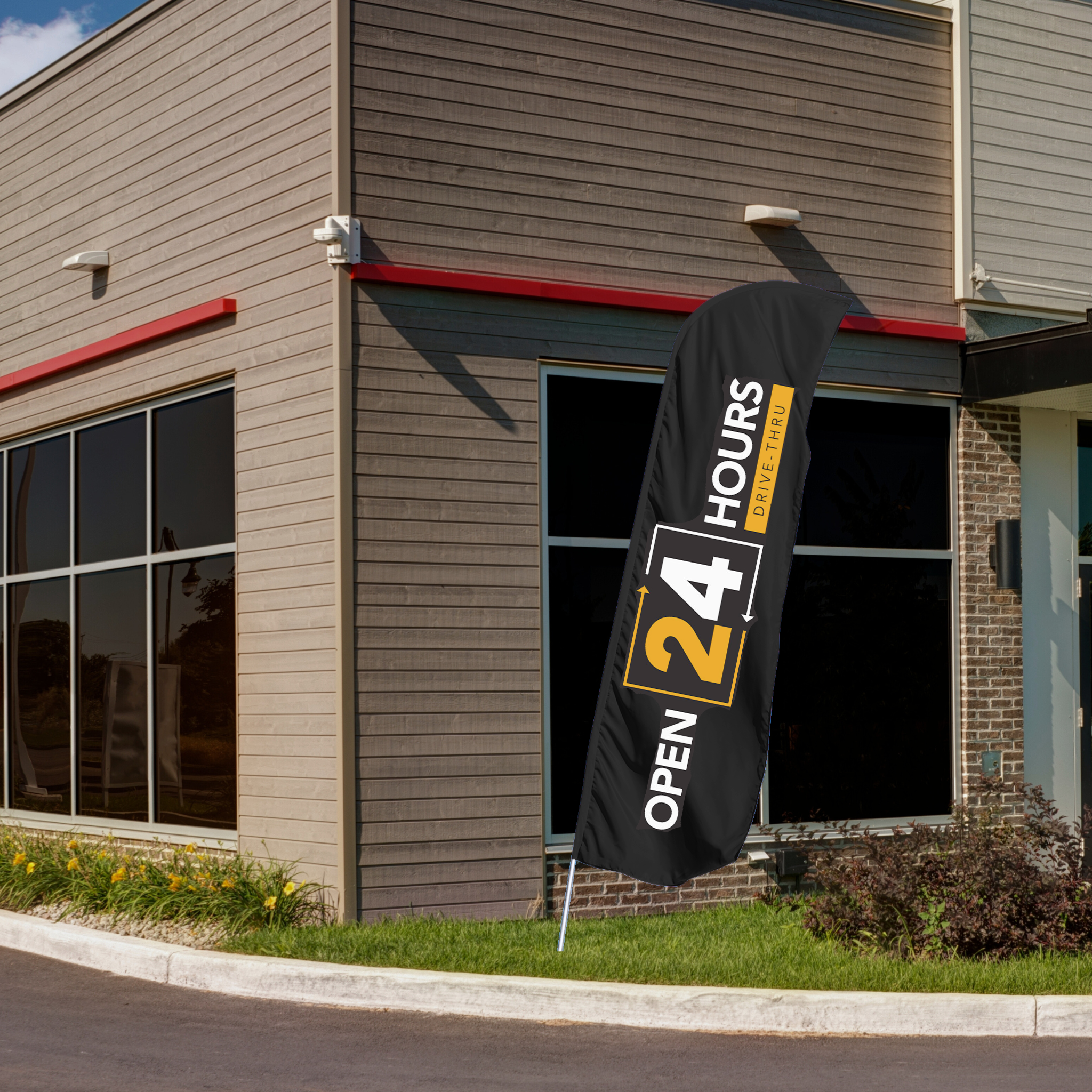 black and yellow 24 hour drive thru flag in front of building