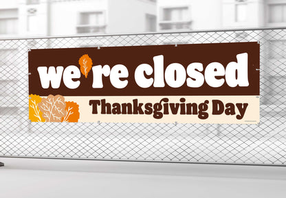 Closed sign for Thanksgiving Day on a chain-link fence.