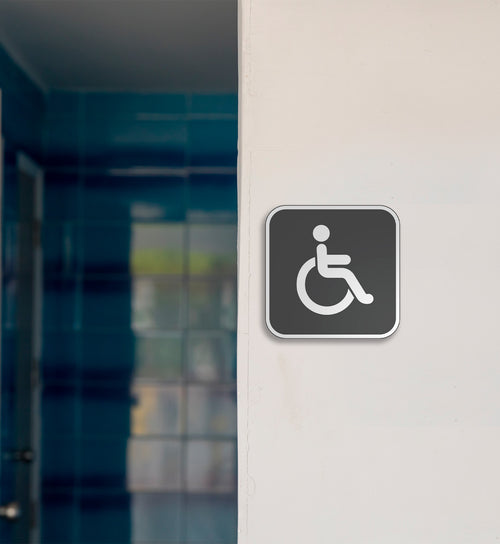 gray and white handicap restroom sign on wall