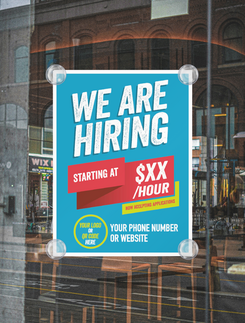 Hiring sign on a glass door with a city street reflection