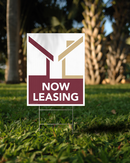 now leasing lawn sign garnet white gold in front of palm tree
