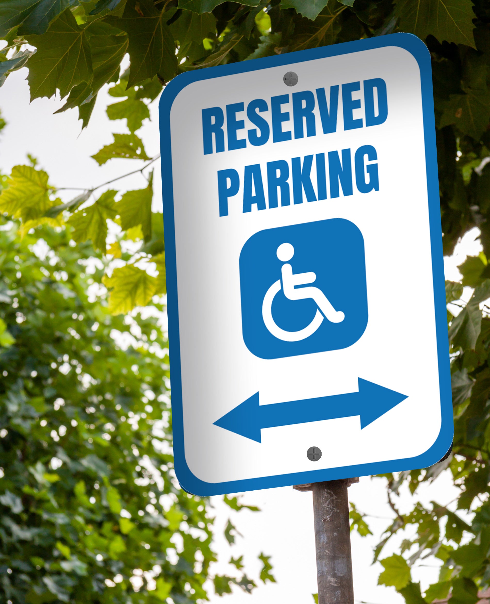 blue and white reserved handicapped parking with arrow pointing in both directions parking sign with tree picture