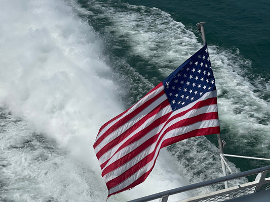 us flag on boat with water and wake background