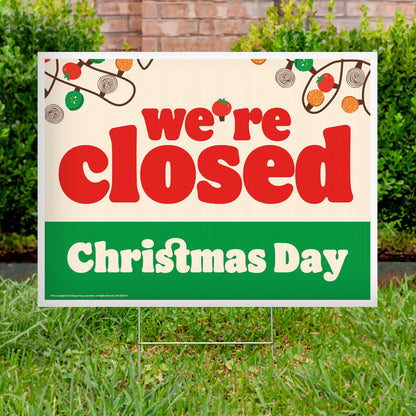 Closed Christmas Day sign on grass with festive decorations