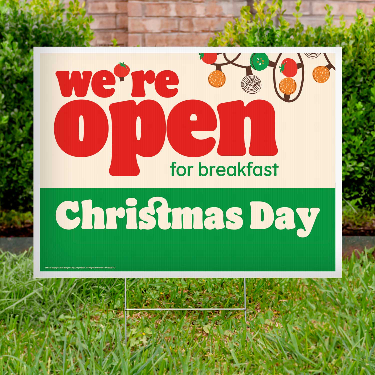 Outdoor sign announcing 'We're Open for Breakfast Christmas Day' on a grassy lawn.