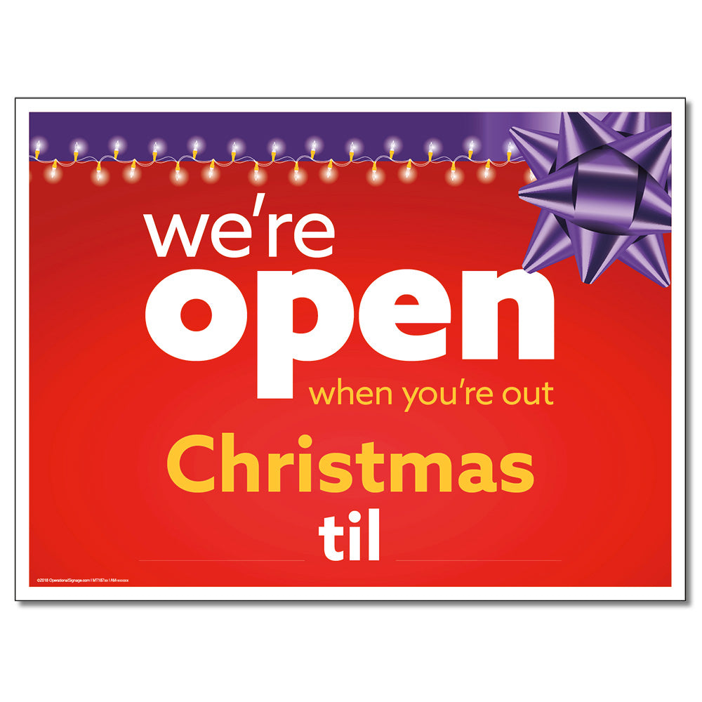 A red lawn sign with white and yellow text that reads 'we're open when you're out Christmas til' with a purple bow and Christmas lights depicted on the sign.